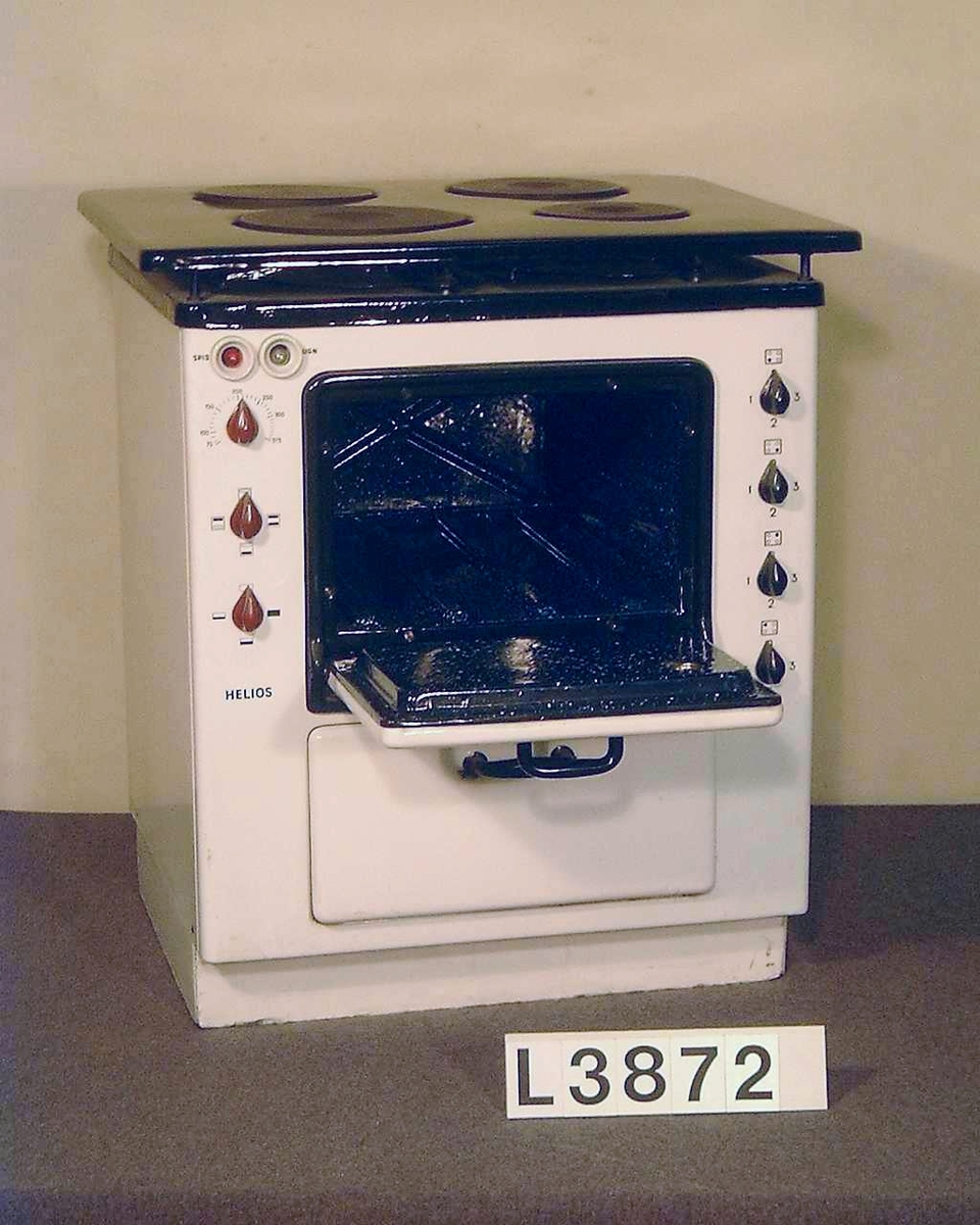 Elspis, med fronten vitemaljerad och upfällbar överhäll i svart emalj. Spisen har fyra plattor, ugn som är termostatreglerad och värmeskåp. Totalt är spisen på 6950 W. Samtliga plåtar finns.