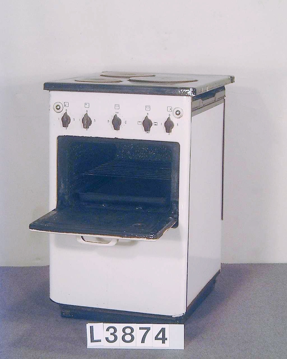 Smalspis med bredden 50 cm. Tre plattor och ugn. Fronten är emaljerad i bengult och den uppfällbara överhällen är emaljerad i svart. Spisen har inget värmeskåp. Spisen saknar vänster sidoplåt.