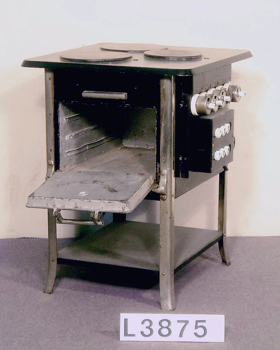 Golvspis på fyra st. kromade ben. Spisen är utförd i svartmålad plåt/järn, med blanka detaljer. Tre st. plattor, två på 1200W och en på 850 W. Ugnen har 500 W övervärme och 500 W undervärme. Tre effektlägen på strömställarna som sitter på sidan. Under dessa sitter en propptavla med åtta st. elektriska säkringar och ett elektriskt urtag.