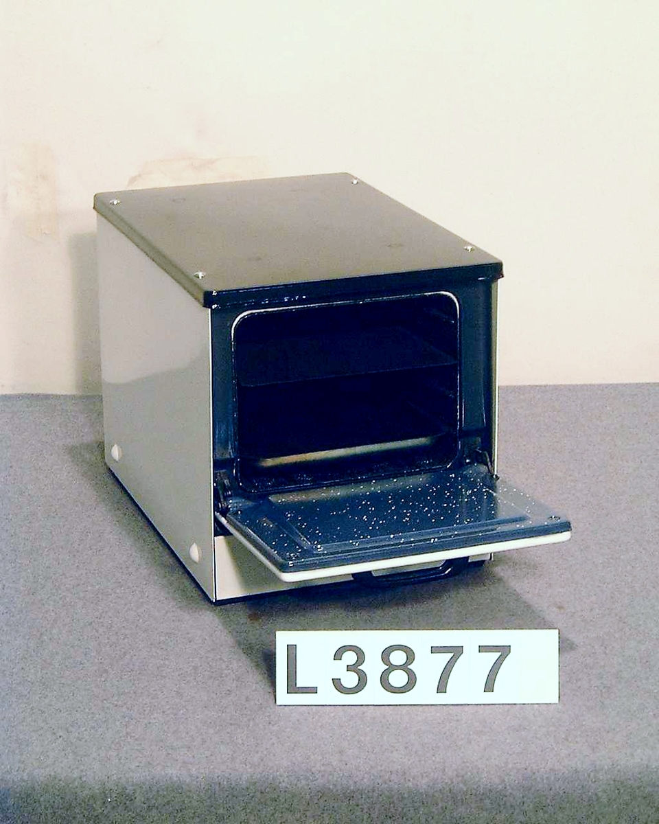 Bänkugn med vitemaljerad front, vitlakerade sidor och svartemaljerad topp. Strömställare med tre lägen. Ingen termostat. Plåtar finns och ugnen är något använd.