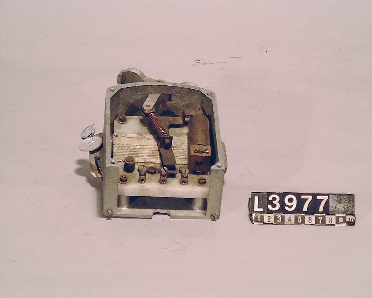 Strömbrytare med startmotstånd. På apparaten finns även en metallbricka fäst med inv.nr. 55.