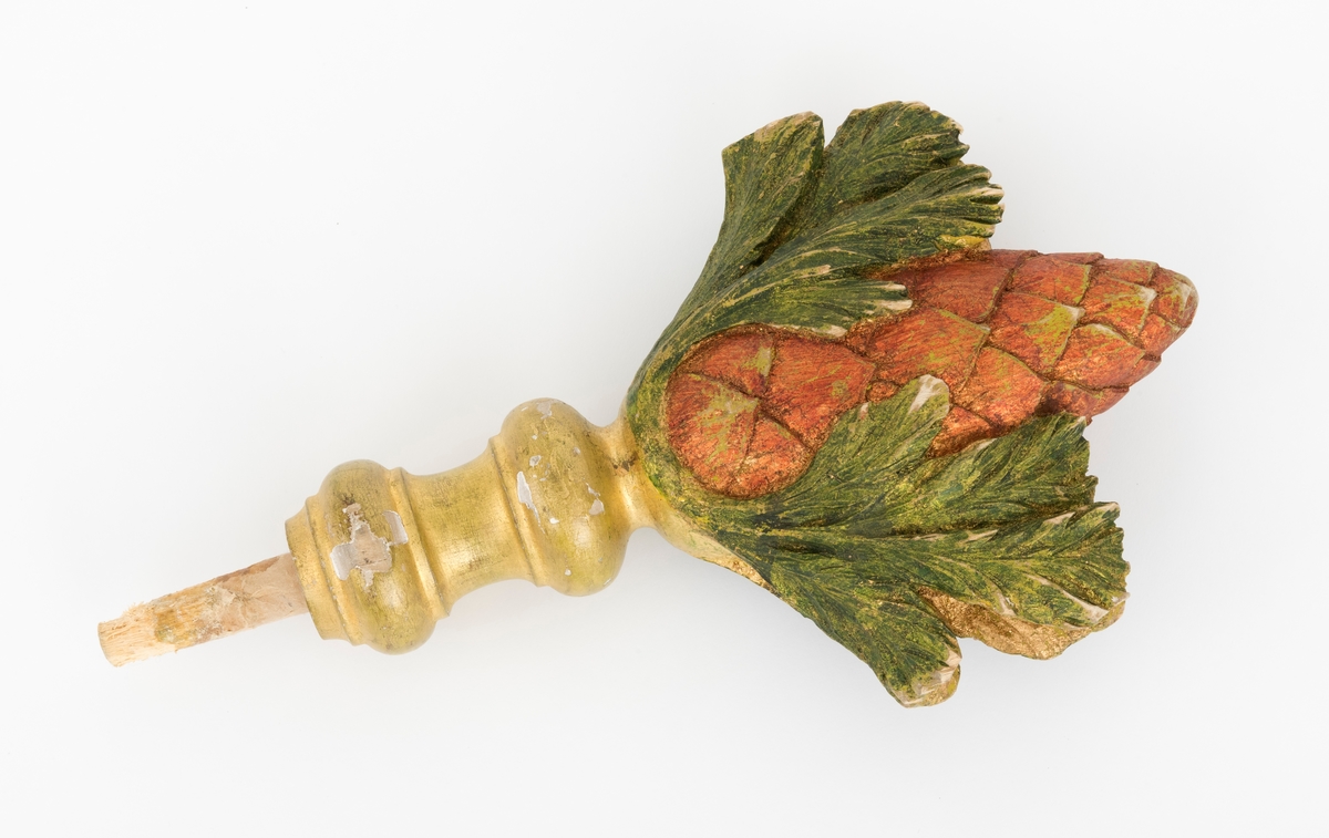 Spydet er formet som en kongle, og den tilhører fanen. Fanen har en tverrgående stang i toppen av fanen. På hver side av denne festes det et spyd i hver av endene.