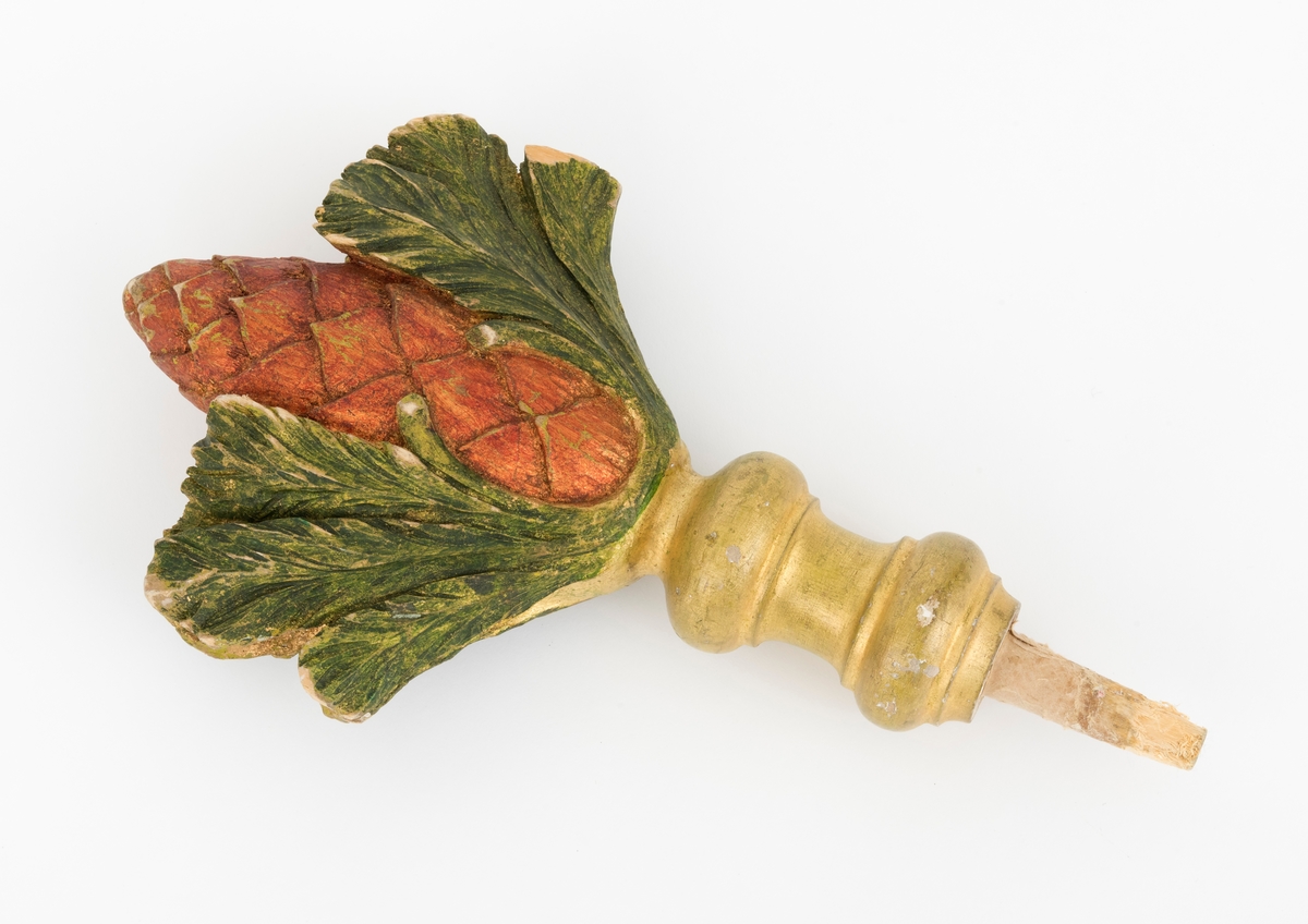 Spydet er formet som en kongle, og den tilhører fanen. Fanen har en tverrgående stang i toppen av fanen. På hver side av denne festes det et spyd i hver av endene.