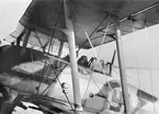 Flygplan Gloster Gladiator med flygförare står på ett flygfält vid F 19, Svenska frivilligkåren i Finland, 1940. Vy från sidan.
