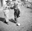 Barn (2) som sparkar boll.