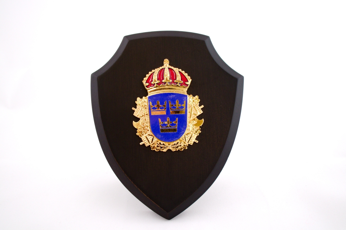 Plakett i tre med svensk politimerke.