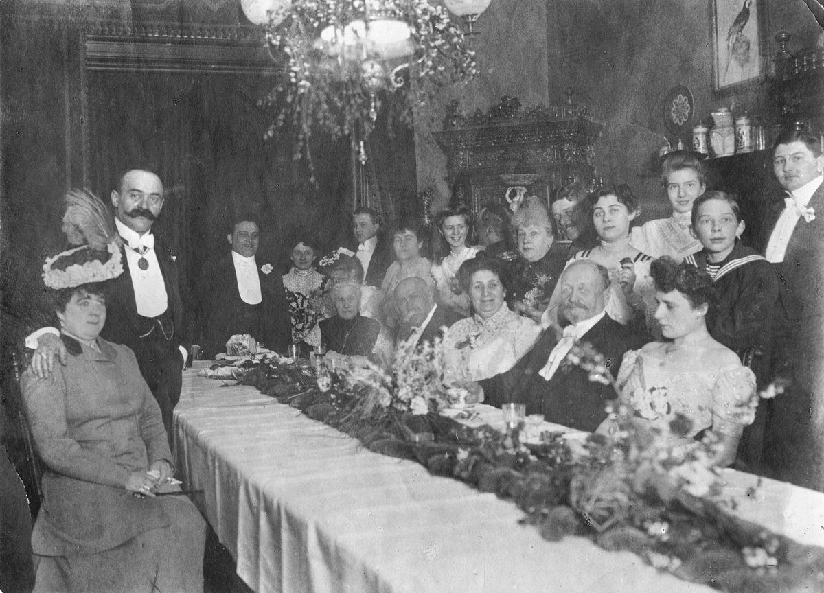 Familien Rostin samlet til selskap.

Foran til venstre: Tante Emilie, født Pfeffer, g.m. Heliodor Rostin, Michails Rostins yngste bror, som står med hånda på sin kones skulder. Stående bak bordet er Florentine (nr. 4 fra venstre). Bak henne skimtes onkel Constantin Cebrian (nr. 5 fra venstre) gift med Leocadie Salome Rostin, kalt tante Lotka ( nr. 9. fra venstre) med mørkt oppsatt hår. Ved bordet sitter Sophia Rostin som nr. 3 fra venstre. Hennes svigerfar Adolph Rostin er nr. 4. og hans kone Paulina (født Szermann) er nr. 5. Øvrige personer på bildet er ikke identifisert, men det er grunn til å anta at dette er et familieselskap.