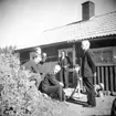 Män och barn utanför ett hus. Släktträff.