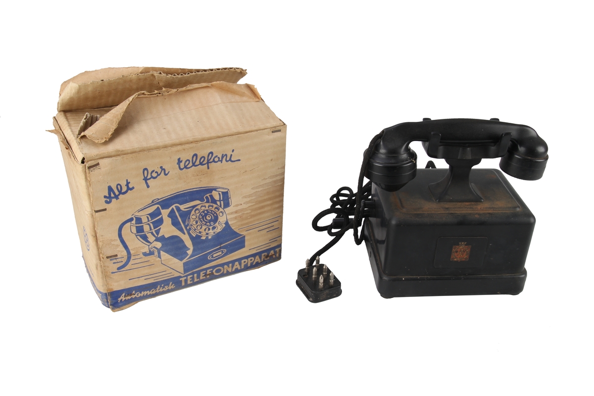 Sveivetelefon i eske. Trolig ikke original eske da det står skrevet "Automatisk" på denne og det er bilde av en telefon med dreieskive. Den aktuelle telefonen er en eldre manuell telefon med sveiv.