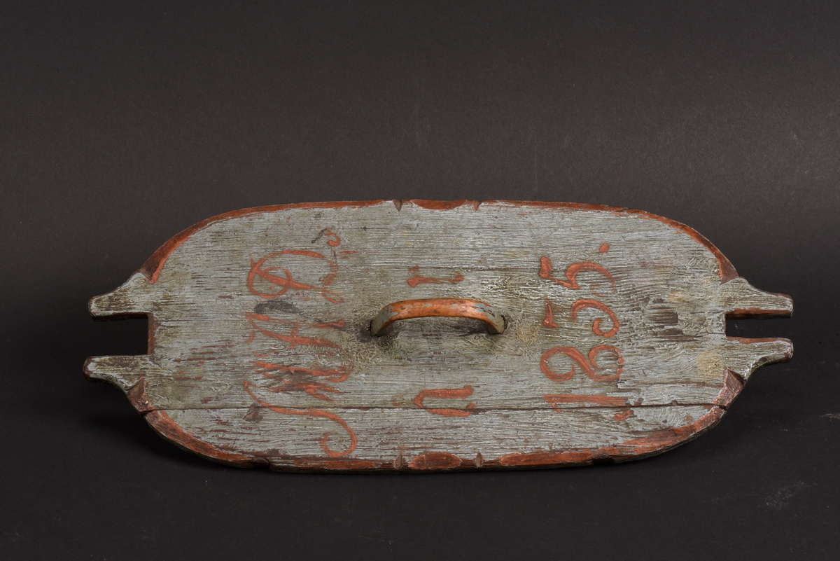 Oval svepask med lock. Målad blå på utsidan. Två ståndare för lockets fastsättning, den ena lite fjädrande. Svepet har ett rakt avslut och ett av fästena för svepet saknas och det andra är kompletterat med ett snöre. Locket har ett handtag och utskurna intag för att passa till ståndarna. Årtalet 1835 och initialerna MAD är målade i rött på lockets ovansida. Sekundär lagning med spik för att fästa ihop svep och botten.
