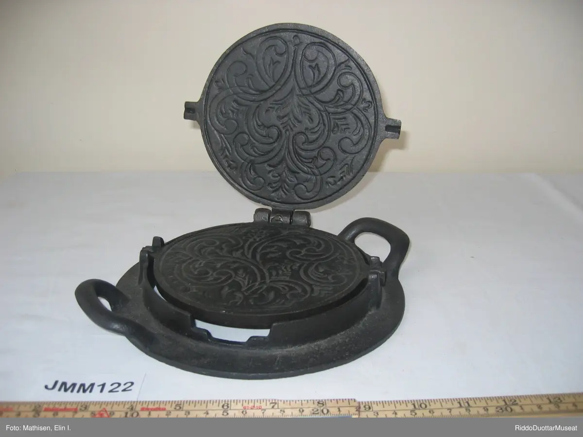 En rund kakeform i et tilpasset stativ  / en holder. Hvis det er åpent rom under stativet, kan kakeformen vippes rundt i stativet så kaken kan stekes på begge sider. Dette jernet er derfor laget for bruk på vedovn med ovnsringer i stedet for kokeplate.  Når man skal steke, fjerner man ovnsringer og legger stativet over åpningen så flammene varmer jernet.
Kakeformen har et mønster preget på innsiden. Den ferdige varme kaken med fint mønster skal straks krummes rundt en kjegle eller en annen rund sak. Kaken tar da en krum form under avkjølingen, derav "krumkake".