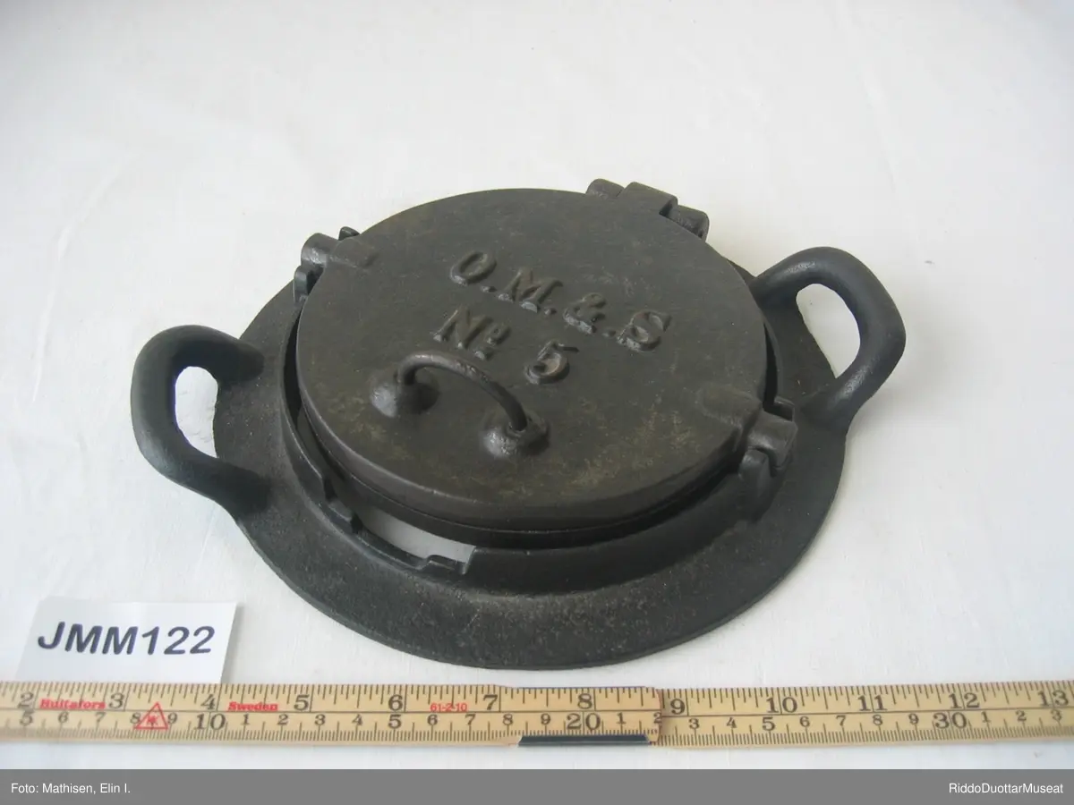 En rund kakeform i et tilpasset stativ  / en holder. Hvis det er åpent rom under stativet, kan kakeformen vippes rundt i stativet så kaken kan stekes på begge sider. Dette jernet er derfor laget for bruk på vedovn med ovnsringer i stedet for kokeplate.  Når man skal steke, fjerner man ovnsringer og legger stativet over åpningen så flammene varmer jernet.
Kakeformen har et mønster preget på innsiden. Den ferdige varme kaken med fint mønster skal straks krummes rundt en kjegle eller en annen rund sak. Kaken tar da en krum form under avkjølingen, derav "krumkake".