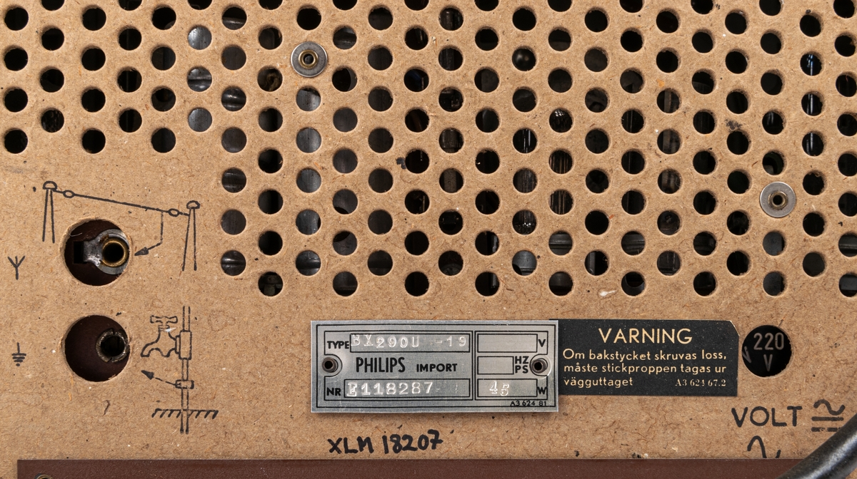 Kat.kort:
Radio. PHILIPS märke på framsidan. Brunt plasthölje. Brungul textil på framsidan. Framför textilien genomskinlig plast med stationsmarkeringar tryckta i gult. Svart sladd med kontakt. Bak- och undersidorna klädda med genombrutet papp. Diverse markeringar på baksidan bl.a.:
"TYPE BX2900-10...
PHILIPS IMPORT...
NR E118287 45W"
"Godkänd för nätanslutning"

