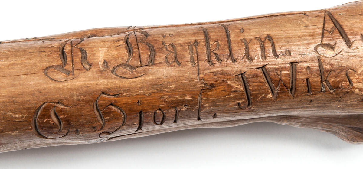 Spatserkäpp, knölpåk, av ene, med att stort antal gävlenamn inristade, flera av dem med studentexamen under 1870-talets första år. 
Käppen är daterad: Kullerhamn och Granskär 27/7 1873.
Namn:
A. Petersson
E. Höjer
A. Nygren
C. Klintberg
F. v. Schéele
A. Ölund
D. Carlsson
O. Nordin
G. Holmström
E. Östman
C. Almgren
A. T. U. Ohlsson
R. Bäcklin
K. G. Hjort
A. Carlsson
J. Wikström
A. Lundeberg
J. Hedeström
W. M. Fröstedt (Wilhelm Mauritz)
F. Sundberg
G. Sandlund