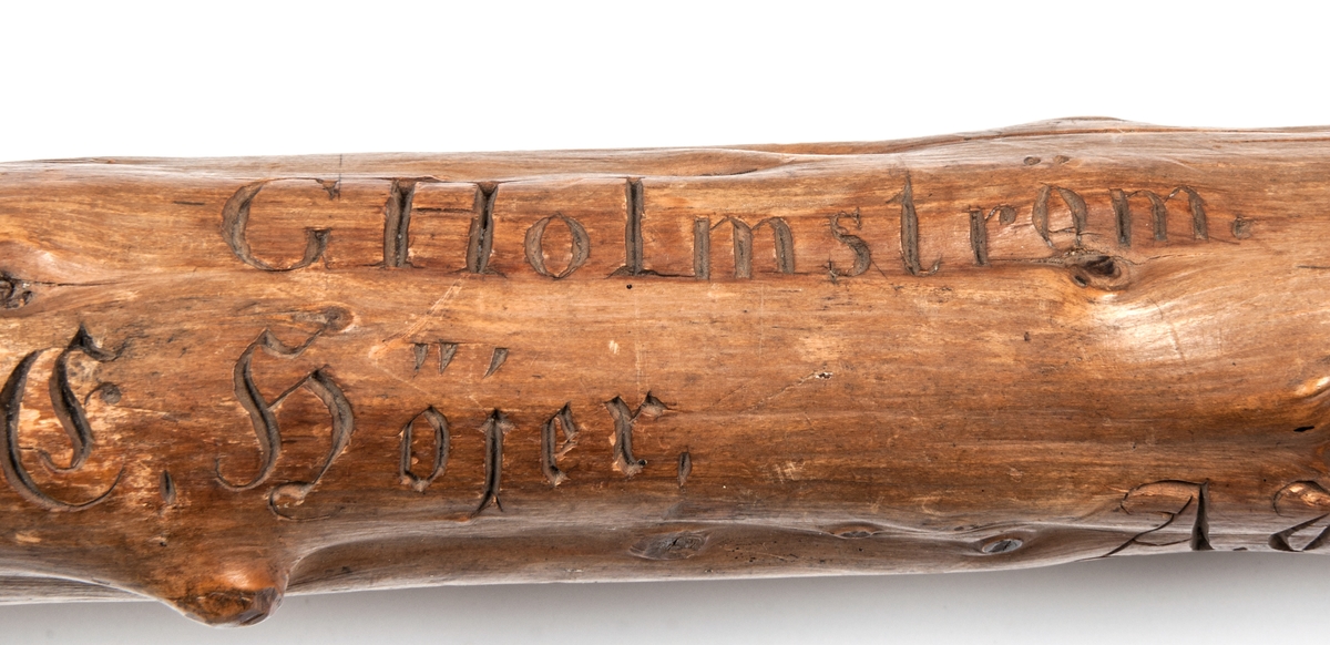 Spatserkäpp, knölpåk, av ene, med att stort antal gävlenamn inristade, flera av dem med studentexamen under 1870-talets första år. 
Käppen är daterad: Kullerhamn och Granskär 27/7 1873.
Namn:
A. Petersson
E. Höjer
A. Nygren
C. Klintberg
F. v. Schéele
A. Ölund
D. Carlsson
O. Nordin
G. Holmström
E. Östman
C. Almgren
A. T. U. Ohlsson
R. Bäcklin
K. G. Hjort
A. Carlsson
J. Wikström
A. Lundeberg
J. Hedeström
W. M. Fröstedt (Wilhelm Mauritz)
F. Sundberg
G. Sandlund