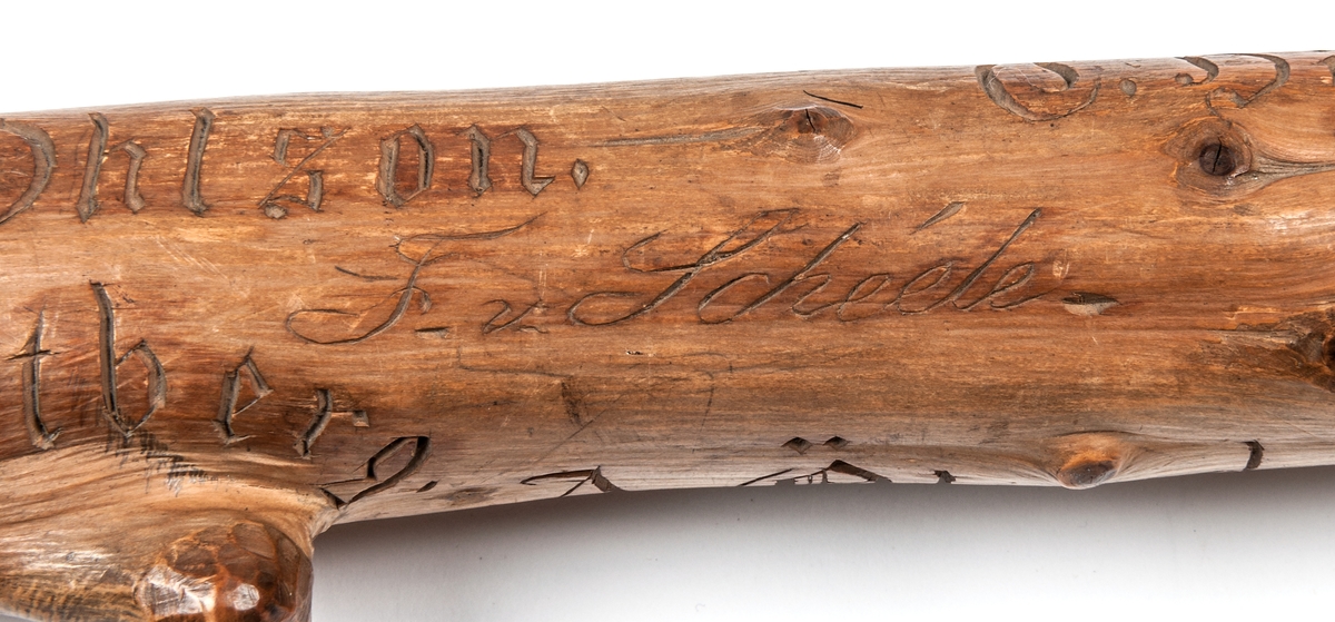 Spatserkäpp, knölpåk, av ene, med att stort antal gävlenamn inristade, flera av dem med studentexamen under 1870-talets första år. 
Käppen är daterad: Kullerhamn och Granskär 27/7 1873.
Namn:
A. Petersson
E. Höjer
A. Nygren
C. Klintberg
F. v. Schéele
A. Ölund
D. Carlsson
O. Nordin
G. Holmström
E. Östman
C. Almgren
A. T. U. Ohlsson
R. Bäcklin
K. G. Hjort
A. Carlsson
J. Wikström
A. Lundeberg
J. Hedeström
W. M. Fröstedt (Wilhelm Mauritz)
F. Sundberg
G. Sandlund