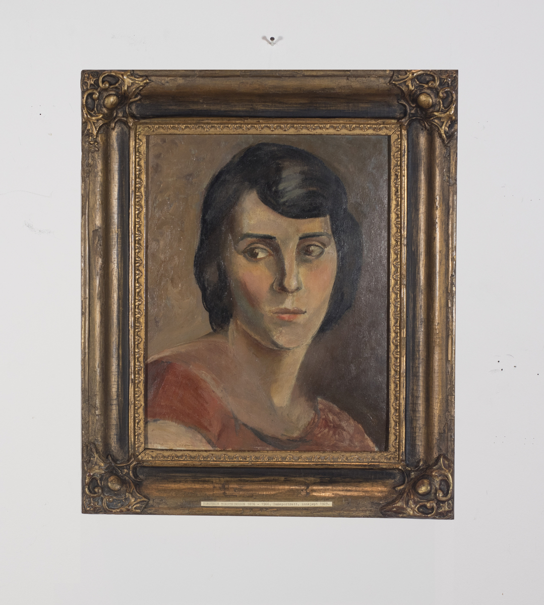 Portrett av mørkhåret kvinne med røde klær.