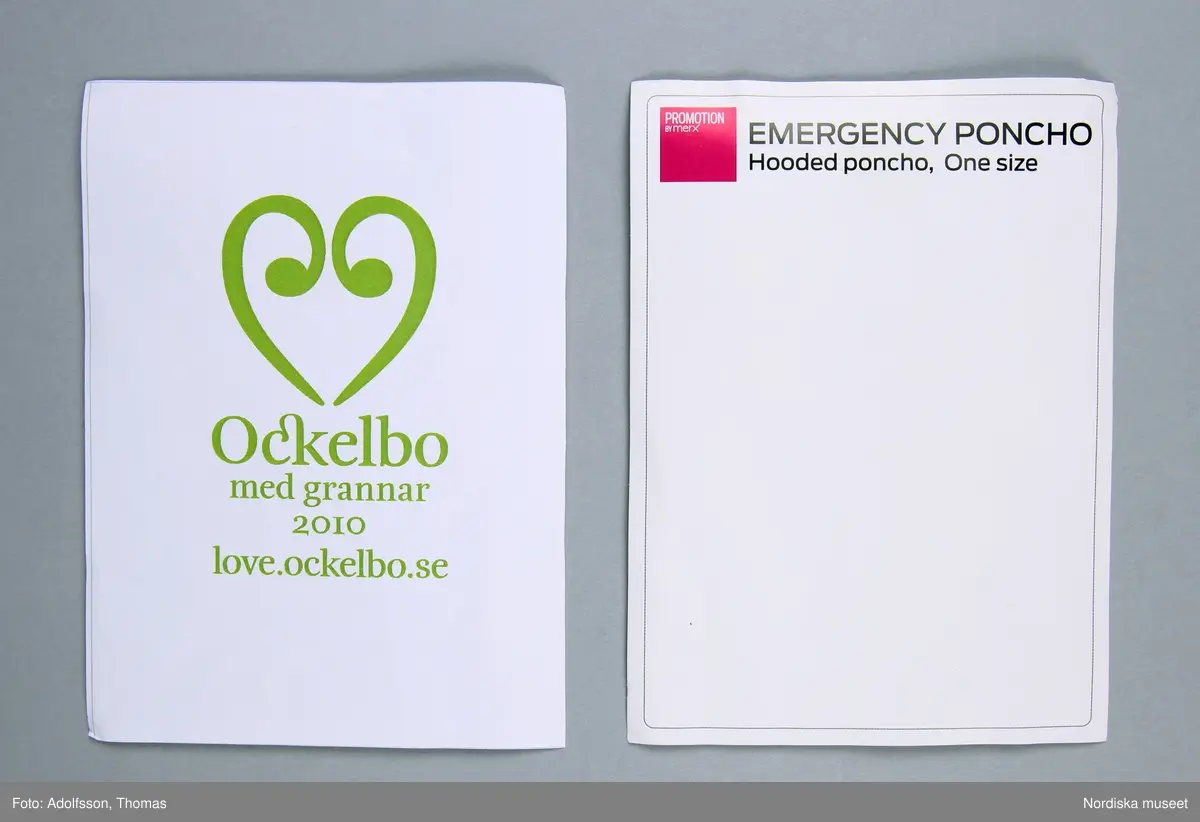a) Regncape/regnponcho av grön tunn plast, med huva. ihopvikt för att passa i plastpåse (plastpåsen ingår ej i förvärvet) Två vita rektangulära papper, b) Det ena med ett grönt hjärta och grön text "Ockelbo / med grannar 2010 / love.ockelbo.se" och c) det andra med rosa ruta med vit text "PROMOTION BY merx" och svart text "EMERGENCY PONCHO / Hooded poncho, One size"
/Leif Wallin 2015-01-07