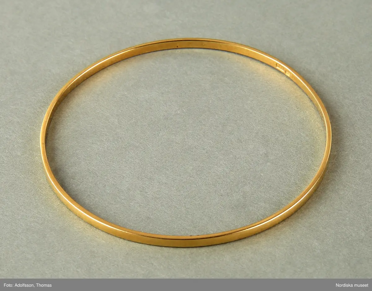 Armringar  i guld,  5 st = 2 st släta utan dekor (a-b), 1 st med dekor med tvärgående räfflor (c) och  2st  med hammrad dekor (d-e).
Samtliga armringar är stela samt utan öppning. Stämplade BJA 585. 


/Cecilia Wallquist 2019-02-15