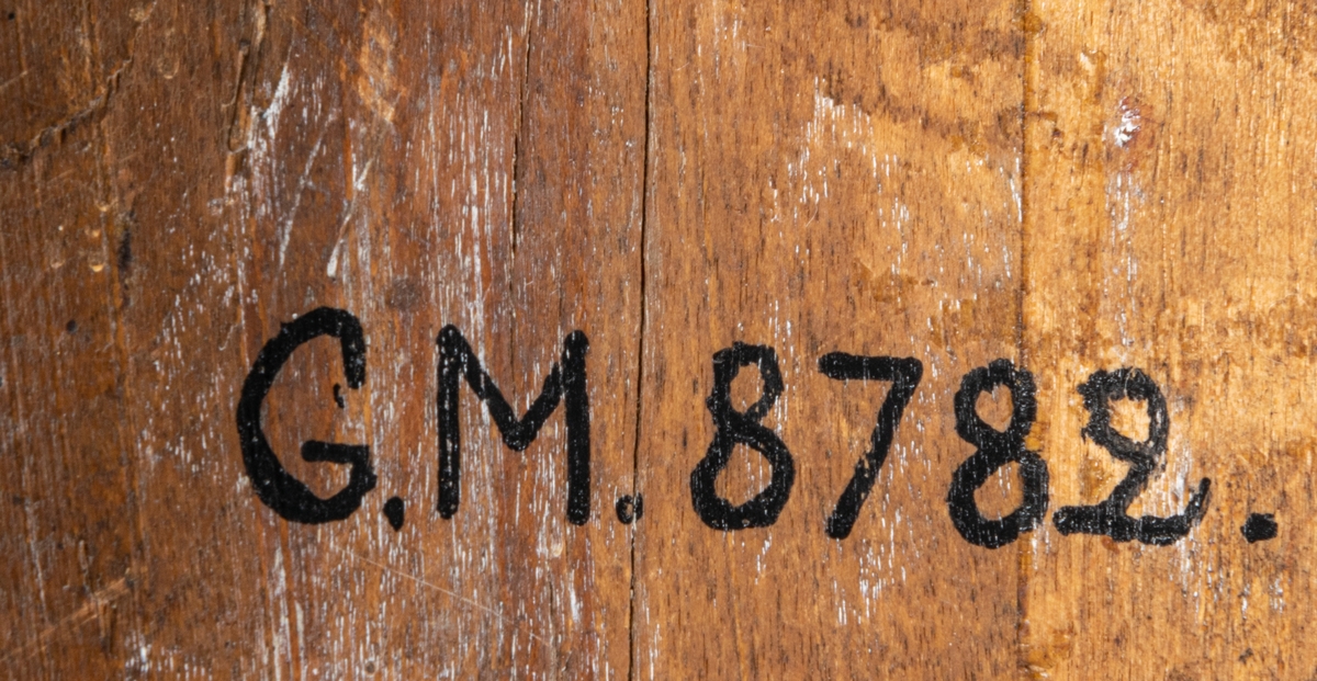 Klockfodral i skuret trä, blåmålat och förgyllt. Reliefbilder; krona, fiskar, delfiner, växtornament samt svårlästa bokstäver (Carl Johans namnschiffer?) samt märkt 1812. Runt hål i mitten.