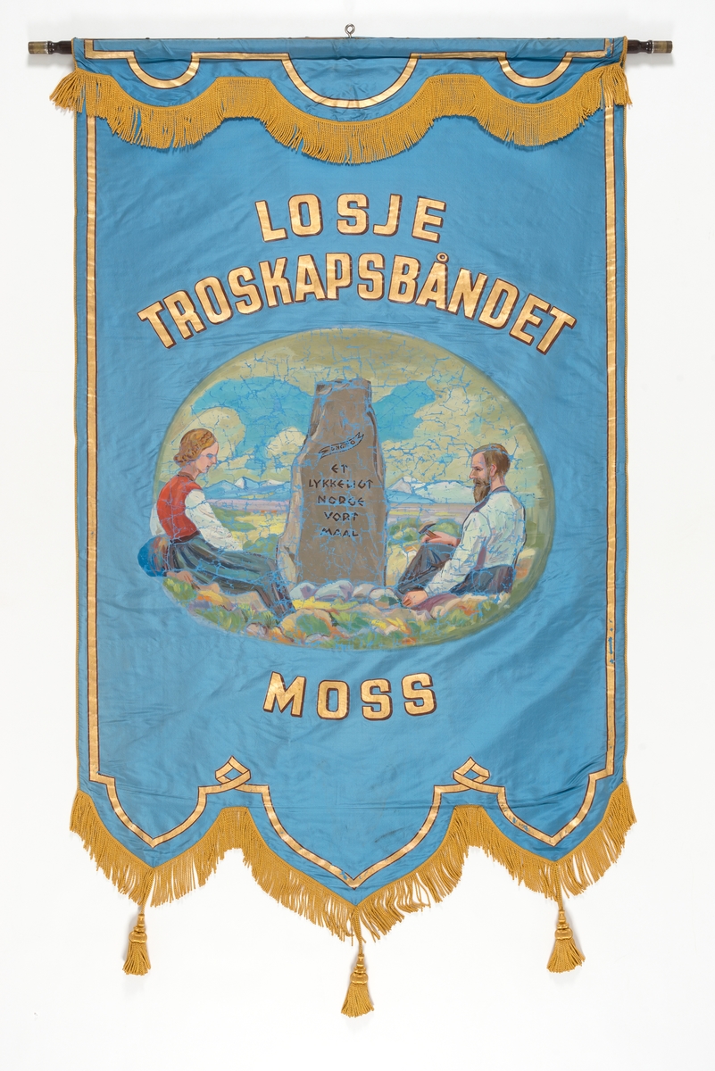 Forside: Kvinne og mann sitter i landskap med bautastein mellom seg. Han er omgitt med verktøy til å hogge i stein. På steinen er følgende innskripsjon: , "DNGTO Et kykkeligt Norge ort maal"., , Bakside: Krans av eikeblader og laubærblader.