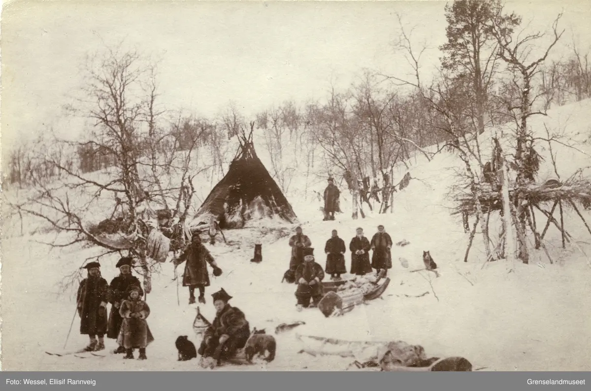 Samisk leir og læstadiansk samling på fjellet ovenfor Sandnesdalen, Sør-Varanger vinteren 1897. Vappus Jon Must står midt i bildet med lua i hånda.