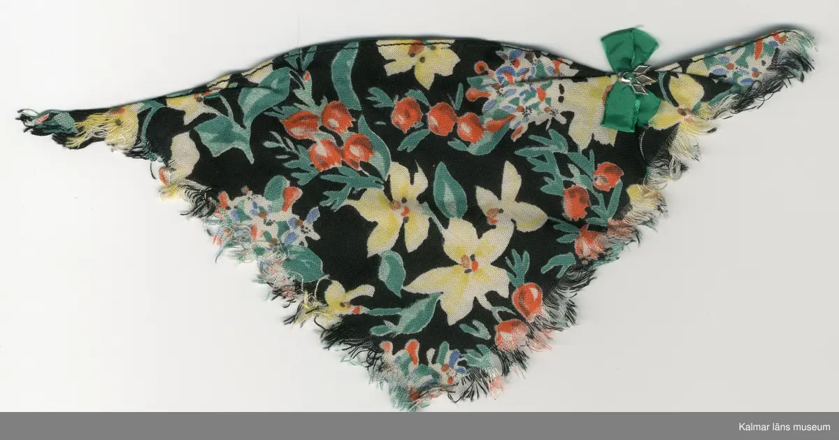 KLM 28082:281:1-4. Dockschal, dam, 4 stycken, del av nationaldräkt, av konstmaterial, med frans, svart botten med blomstermotiv i gult, rött, blått, vitt, grönt, brunt och svart. Knäppes med hake av metall, svart och trådhyska, grön. 
:2 och :3 Schalar, med rosett, grön och brosch, silverfärgad.