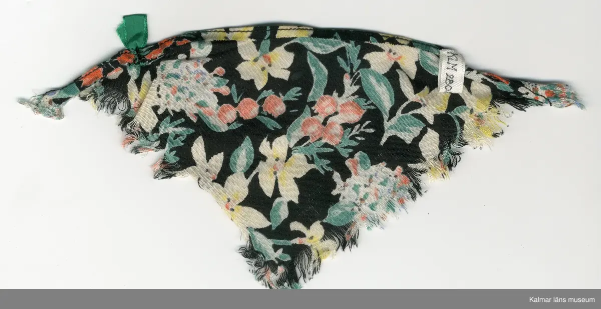 KLM 28082:281:1-4. Dockschal, dam, 4 stycken, del av nationaldräkt, av konstmaterial, med frans, svart botten med blomstermotiv i gult, rött, blått, vitt, grönt, brunt och svart. Knäppes med hake av metall, svart och trådhyska, grön. 
:2 och :3 Schalar, med rosett, grön och brosch, silverfärgad.
