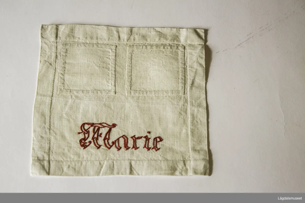 Stoppelapp med brodert "Marie" i rødt.