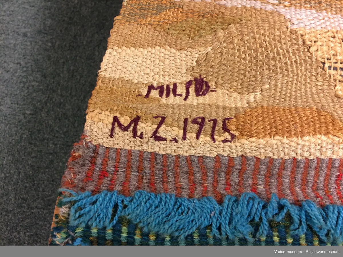Billedvev "Miljø". Brukt naturfarget tråd og garn, finklipte mattefiller, sisal, sølv- og gulltråder og gamle glidelåser. Har en eldre skade-blitt reparert tidligere, men trenger ny reparasjon.