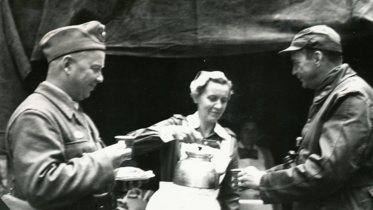 Rikshemvärnstävlingen 1967, sid 37

Kaffepaus -- förmodligen i den nu nedbrända Skyttepaviljongen vid Stora skjutbanan

Bild 1. Styckjunkare Rune Berggren, SJ, Hälsingborg, Lotta Karin Larsson och general Almgren
 
Bild 2. Lotta Elsa Wetterberg serverar general Göransson kaffe
(Elsa Wetterberg förestod Oscar Ericsons bokhandel i Strängnäs under många år)

Bild 3. General Synnergren är också kaffetörstig. Får här hjälp av lotta Betty Rosenius.