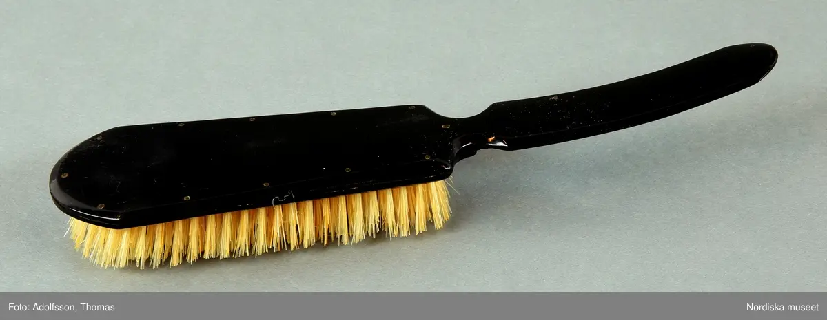 Huvudliggare:
"Spegellåda med maskeringstillbehör. Tillhört såsom föregående [Lagerqvist, Carl Fredrik, skådespelare, f. 1819, d. 1897.]
a. Låda. H.0,110. L.0,345. B.0,292. Af gulbetsadt trä, aflång fyrkantig med utfällbar spegel i locket. Med nyckel. Å främre kortsidan finnas två lådor, af hvilka den större, indelad i två större och tre mindre fack innehåller: b.Kam. c.Borste. d.Handspegel. e.Sax i fodral. f. Sax. g.Knif.  h.2 Penslar. i.Fodral inneh. penslar m.m. j.Fodral inneh. färg. k.3 runda askar, inneh. blyvitt, gulockra, brun bolus. l.2 sminkburkar (?). m.Gummiflaska. n.Aflång ask, inneh. diverse.
Den mindre lådan innehåller: o.Nackspegel. p.Lösskägg."