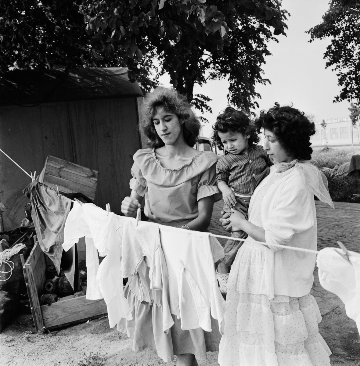 Monika och Laila Taikon med brorsonen Janos hänger tvätt, Uppsala 1963