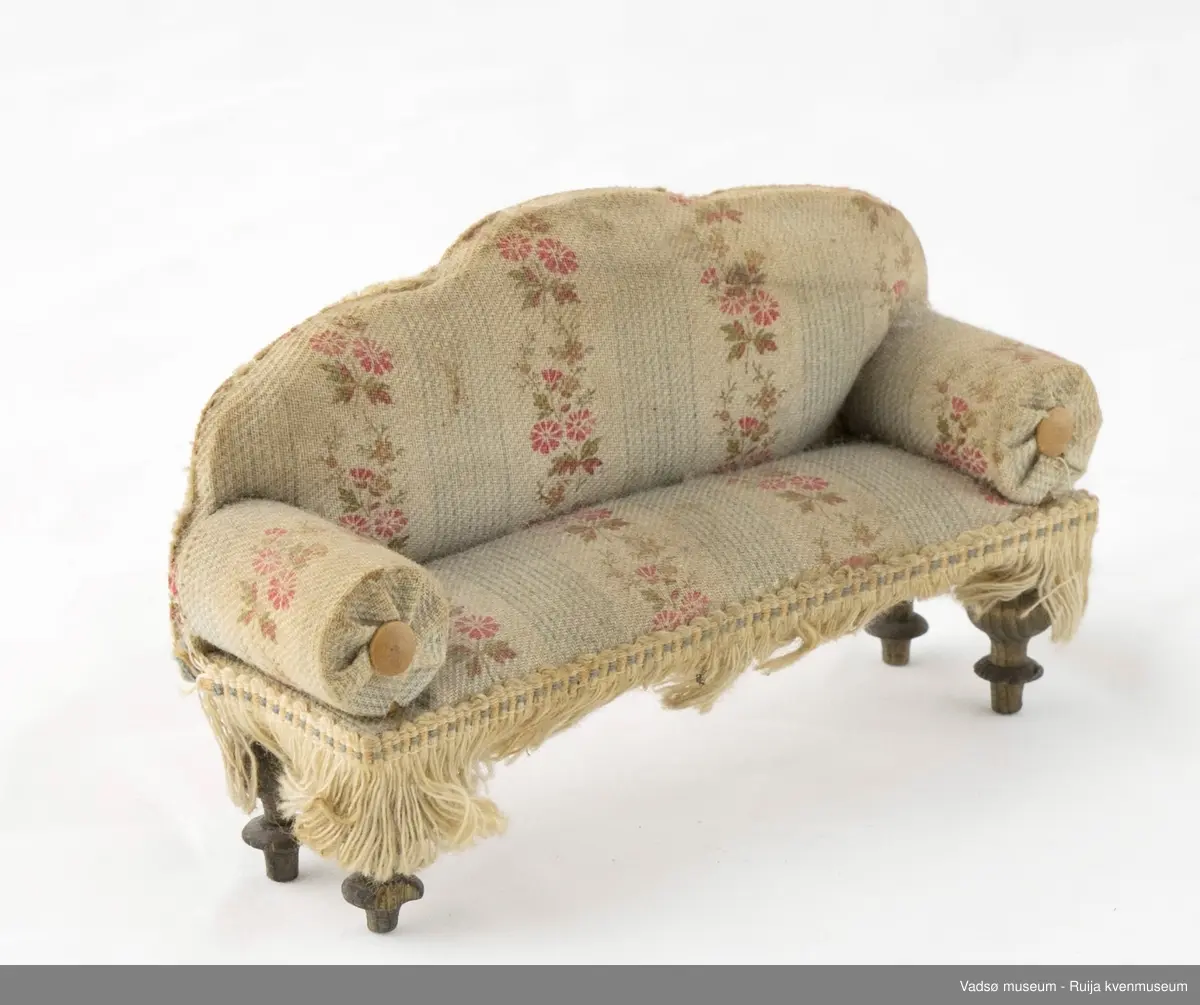 Sofa i miniatyrstørrelse. Kledd i sandfarget tekstil. Dreide bein.