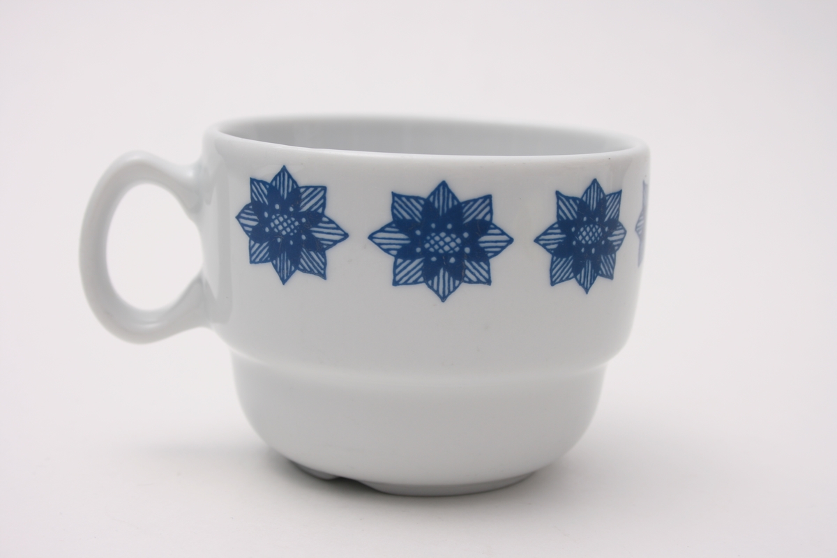 Kopp med hank. Dekorert med en bord langs øvre del av koppen. Dekorbord består av åtte blomster.