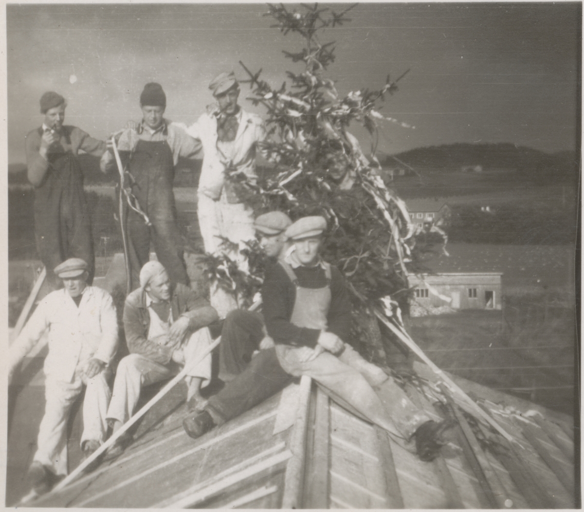 Ombygging av murbygget på Falstad (nå Falstadsenteret) i 1949-50. Taket ble ombygd slik at bygget fikk to fulle etasjer, og det ble også foretatt innvendige endringer. Det var håndverkere fra Lunner på Hadeland som utførte arbeidet. Bildet er tatt på hjørnet mellom øst- og nordfløya, da de holdt kranselag etter at taket var tett. Foran fra venstre sitter Nils Svensbråten, to ukjente og Trygve Lyseng. Bak fra venstre står Leif Svensbråten, en ukjent og Arild Svensbråten.