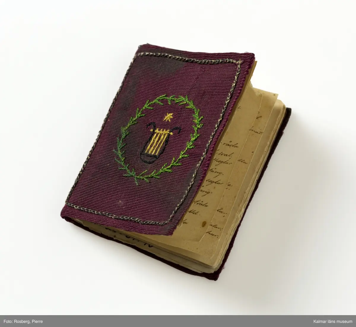 KLM 28634:40, Häfte, av papper och textil. Poetiskt Album. Litet poetiskt häfte med handskrivna verser och dikter. Innehåller sju handskrivna dikter. 27 blad. Pärmarna klädda med vinröd sidenrips med broderier.