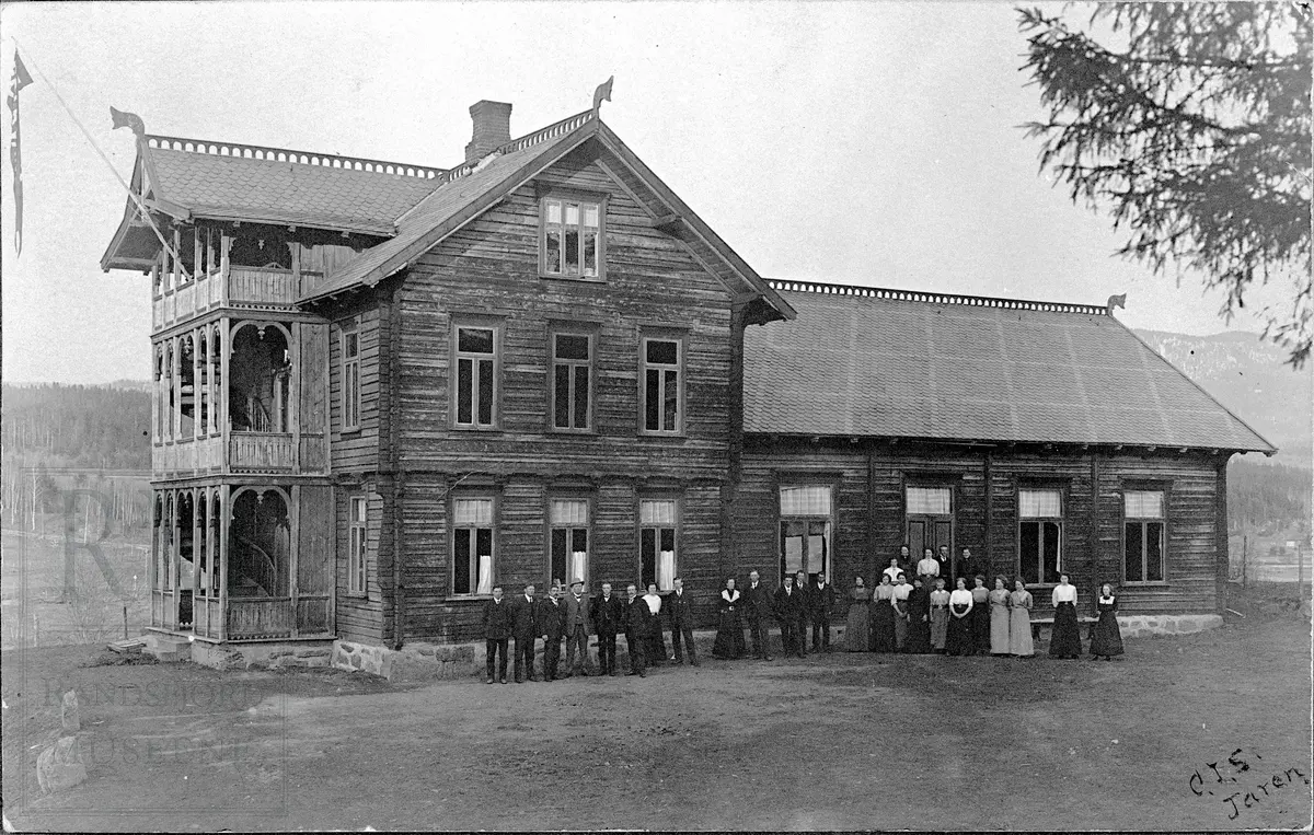 Ungdomshuset Folkvang med menn og kvinner oppstilt ved huset. 