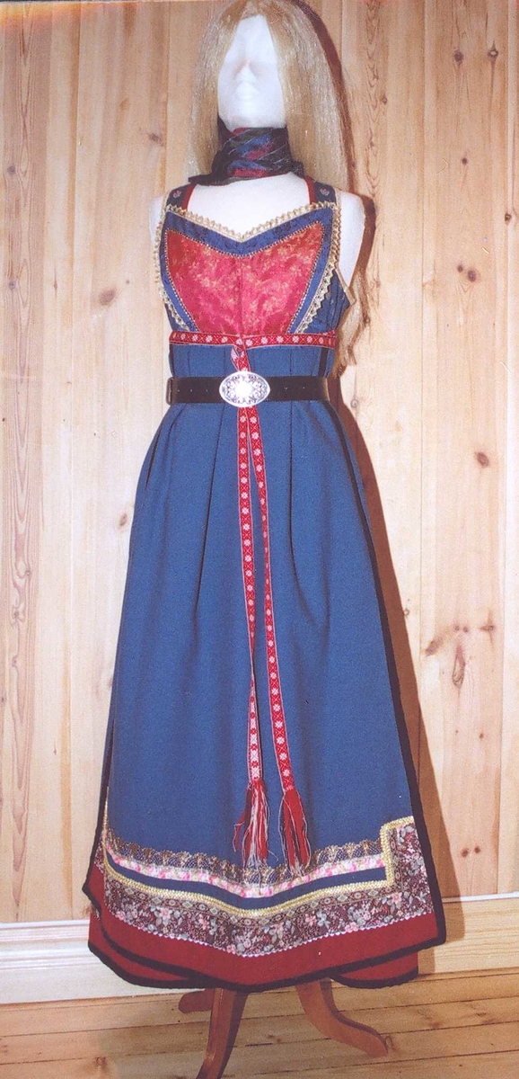 Uppluten sydd av blomstrete tøy og har perler bak. Kanta med ull og bomull. Bringekluten kan brukast på begge sider, raud på den eine, blå og lys gul på den andre. Forkleet kan og brukast på begge sider, blått på eine sida, lyst på den andre. Beltet skal brettast ned, slik at det framleis viser rettsida ut, når forkleet blir bruka på den blå sida. Forkleet er kanta med blått fløyelsband. Forkle, stakk og bringeklut er pynta med agramaner i gull og sylv. Band til pynt, ingen broderi. Drakta kan brukast i ulike samanhengar. Høgtidskledd med raud bringeklut. Med kvitt forkle er det eit endå meir høgtidsprega. Dersom ein i tillegg har la og belteklutar så er det brurestakk. Brukar ein lærbelte, er det meir kvardagplagg. Drakta kan varierast med forskjellige skjorter, sylv, plagg, og kan passe til mange typar bruk. Med den lyse sida av bringekluten fram er det meir kjøkkenfargr og meir sommarleg. Utan bringeklut kan ein bruke silkeplagg i bringa. Med  mindre pynt vert han tøffare, ein kan nesten bruke T-skjorte i staden for bunadsskjorte. 