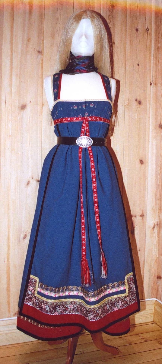 Uppluten sydd av blomstrete tøy og har perler bak. Kanta med ull og bomull. Bringekluten kan brukast på begge sider, raud på den eine, blå og lys gul på den andre. Forkleet kan og brukast på begge sider, blått på eine sida, lyst på den andre. Beltet skal brettast ned, slik at det framleis viser rettsida ut, når forkleet blir bruka på den blå sida. Forkleet er kanta med blått fløyelsband. Forkle, stakk og bringeklut er pynta med agramaner i gull og sylv. Band til pynt, ingen broderi. Drakta kan brukast i ulike samanhengar. Høgtidskledd med raud bringeklut. Med kvitt forkle er det eit endå meir høgtidsprega. Dersom ein i tillegg har la og belteklutar så er det brurestakk. Brukar ein lærbelte, er det meir kvardagplagg. Drakta kan varierast med forskjellige skjorter, sylv, plagg, og kan passe til mange typar bruk. Med den lyse sida av bringekluten fram er det meir kjøkkenfargr og meir sommarleg. Utan bringeklut kan ein bruke silkeplagg i bringa. Med  mindre pynt vert han tøffare, ein kan nesten bruke T-skjorte i staden for bunadsskjorte. 