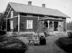 TVÅ KVINNOR, MOR OCH DOTTER, SITTER PÅ EN BÄNK FRAMFÖR ETT BOSTADSHUS