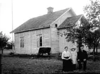 FAMILJ FRAMFÖR SITT TIMRADE BOSTADSHUS. EN KO BETAR VID STUGKNUTEN.