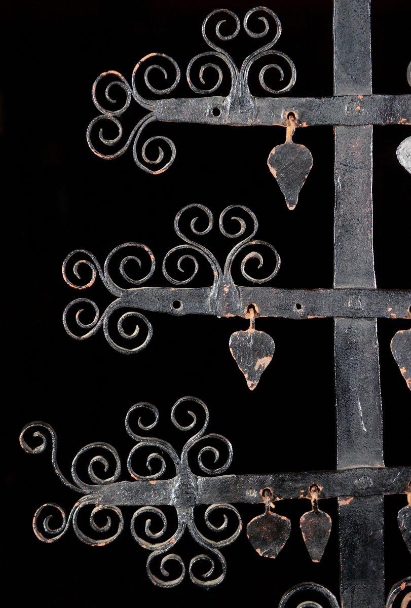 Föremålet består av en järnstam, sex korslagda armar med ornament och en järnplatta med inskription. Gravkorset är av Ekshäradskaraktär. Det är högt med många tätt placerade armar som tillsammans bildar en rombisk form. Riklig dekor. Korset har formen av ett stiliserat träd - ett livsträd som symbol för döden. Armarnas ändar utgörs av utklyvningar som upprullats mot varandra och bildar dekorativa stilistiska löv. Den 2:a armen uppifrån har en (av två tenar vriden) spira på var sida av stammen. 3:e och 4:e armen har två uppåtställda ornament utformade som löv. 5:e armen är försedd med ett tvärställt ornament på var sida om stammen. Korsets topp är krönt med en liknande utsmyckning. Fyra av armarna har uthuggna hål ämnade för hjärtan som är däri fästade med en järnögla. Samtliga 4 hjärtan finns i 5:e armen. 4 av 6 hjärtan finns i 4:e armen. 3 av 4 hjärtan finns i 3:e armen. 1 samt del av ett hjärta finns i 2:a armen. Ovanför nedersta armen på var sida om stammen finns en järnten uppåtböjd och upprullad i en dekorativ form. Nedre delen av stammen är smidd i en spiral. En kvadratisk järnplatta med uthuggen inskription är placerad mellan översta armen och stammens topp. Text: Här under wiler lila LSS från Nedra Wärnäs föd d 30 iuli 1815 död d 4 ocktober 1819 samt 5 aflefne syskon tilhörer SPS H MRD I W. LSS = Lars Svensson, SPS = Sven Persson, H = hustru, MPD = Maria eller Marita Persdotter.