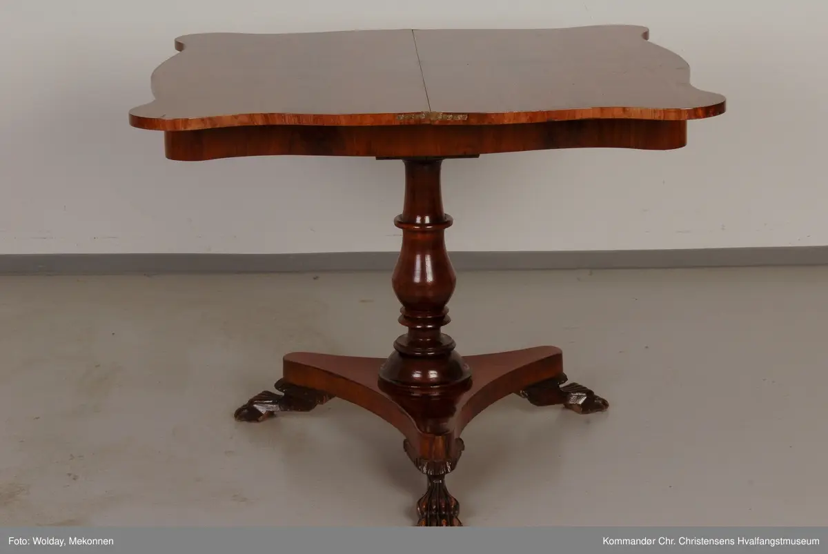 Bord hvor platen holdes oppe av dreid sokkel som hviler på fotplate med 3 utskårne bein. Bordplaten er hengslet på midten
Platen har avrundede hjørner