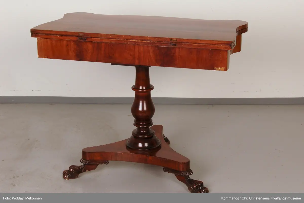 Bord hvor platen holdes oppe av dreid sokkel som hviler på fotplate med 3 utskårne bein. Bordplaten er hengslet på midten
Platen har avrundede hjørner