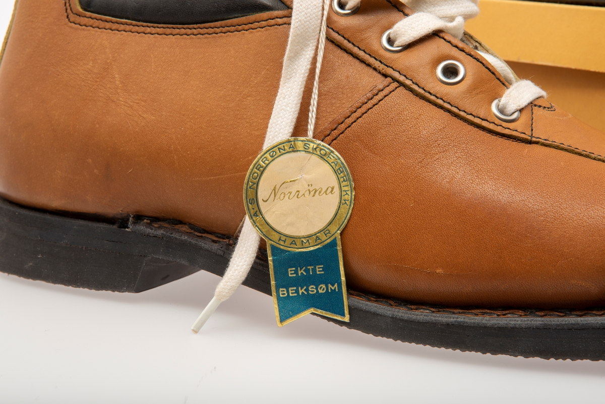 Skisko/Beksøm, lys brune med sort ankelstøtte. Sort gummisåle. Hvite skolisser. Hull til rottefellebindinger. Størrelse 41.