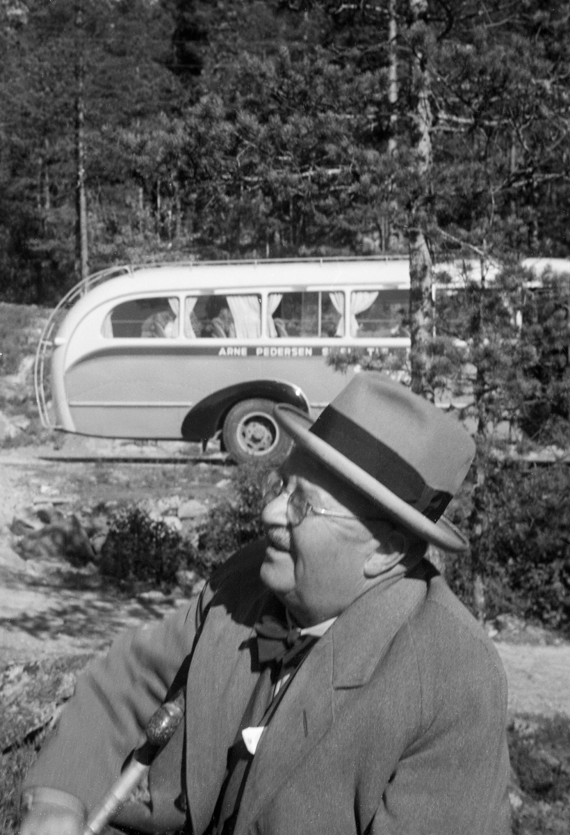 Portrett av den finske diplomingeniøren Ernst Ane Löther (1886-1985). Han hadde vært fløtingsfunksjonær i Kymmene-elva i Sør-Finland (Kymijoki på finsk), men da dette fotografiet ble tatt hadde han fått en stilling som fløtingsråd i Helsinki. Löthner er fotografert sittende i friluft, iført lys dress med vest og skjorte under, og med sløyfe i halsen. På hodet hadde han en lys hatt med et svart band rundt den nedre delen av pullen. Det ser ut til at Löthner hadde en spaserstokk i fanget da dette fotografiet ble tatt, under en ekskursjon langs Skiensvassdraget med medlemmer av Norsk fløtningsforbund og Nordisk fløtningsråd høsten 1952. I bakgrunnen ser vi den bakre delen av ekskursjonsbussen, som tilhørte bussoperatøren Arne Pedersen i Skien.

Löther arbeidet lenge som fløtingsfunksjonær i sagbruksbyen Kotka, som ligger ved ett av Kymmenes utløp i Finskebukta. Seinere fikk han altså en posisjon som fløtingsråd i Helsingfors. Löthner døde i Åbo, og kan muligens ha levd der som pensjonist.