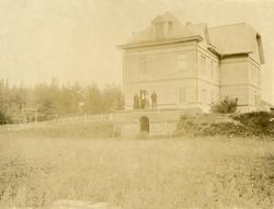 Michael Rostin med kone og en av døtrene foran et hus, antag