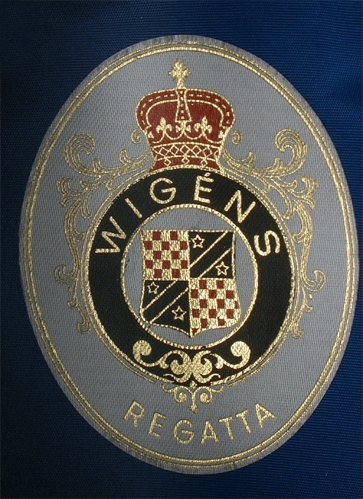 Vit herrmössa med platt kulle. Snodd mitt fram som knäppes i sidorna. 
   Mått: Runt kullen 620 mm. Kullens höjd 80 mm. 
   Storlek: 56.