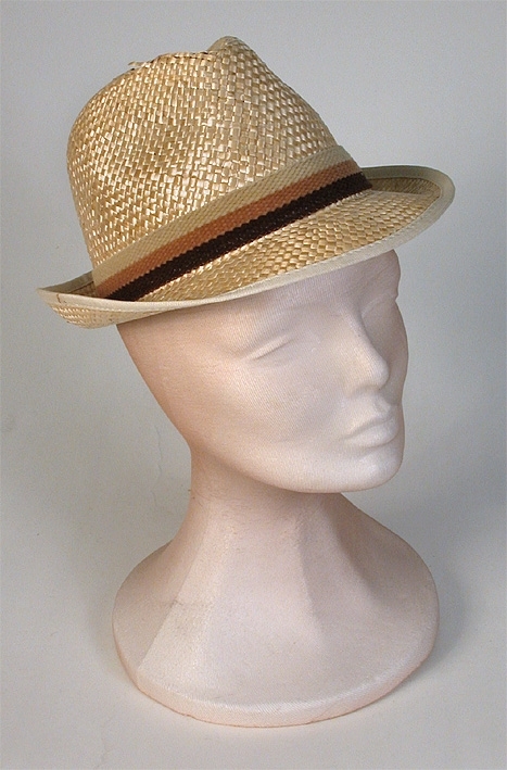 Herrhatt av halm. Tillverkad i Spanien. Ripskantat brätte, uppvikt bak. 
   Mått: Kullens höjd 100 mm. Runt kullen 570 mm. 
   Storlek: 56.